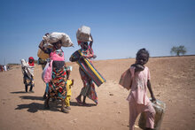 South Sudan. Families carry their belongings as they arrive to South Sudan after fleeing fighting in Sudan